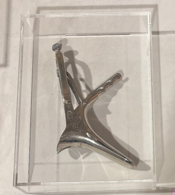 Vaginalspekulum nach Seyfert aus Metall in einer Acrylglas-Vitrine